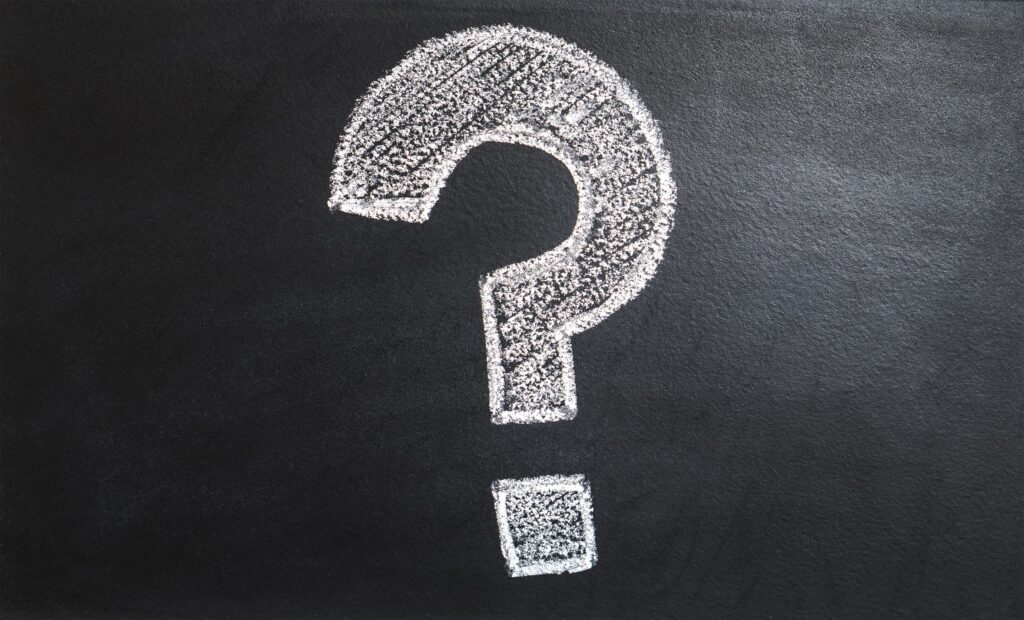 A white question mark on a blackboard representing Serbian question words.