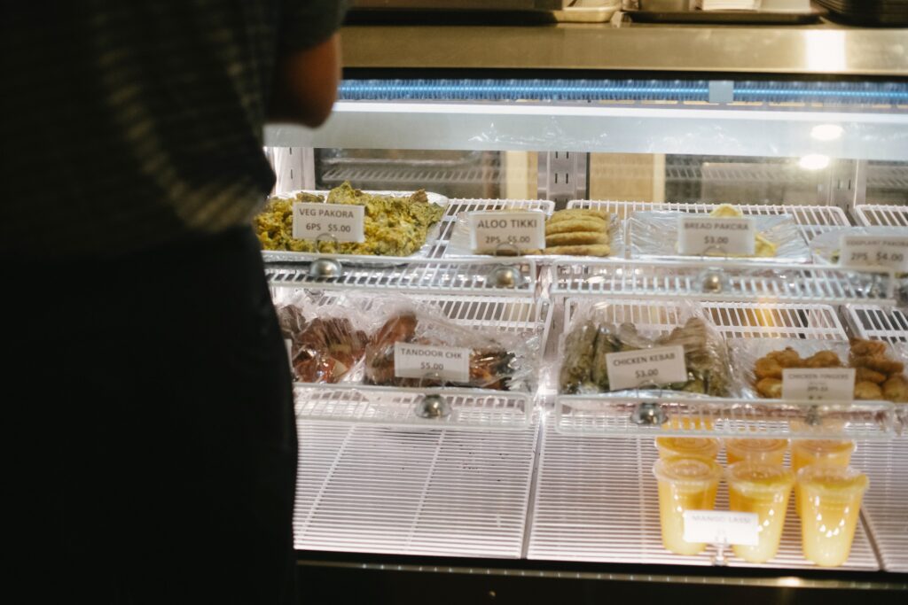 A man in a pastry shop trying to buy cake while asking questions in Serbian