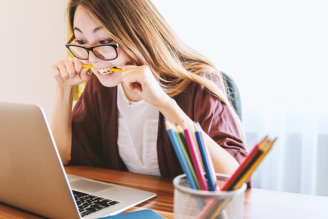 A frustrated language student biting a pencil