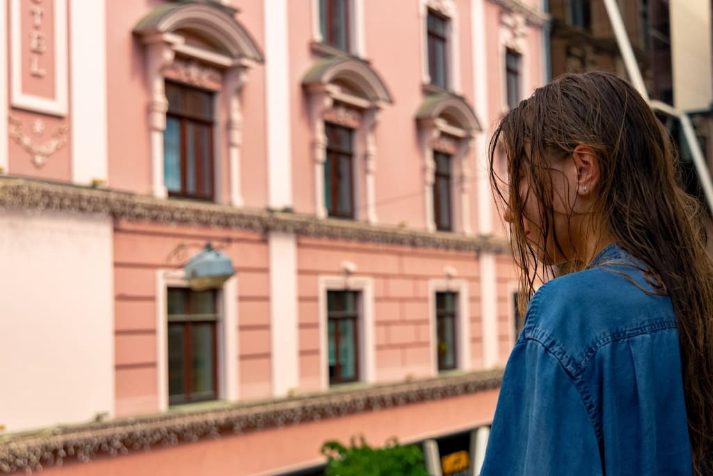 A girl with wet hair standing outside on a balcony