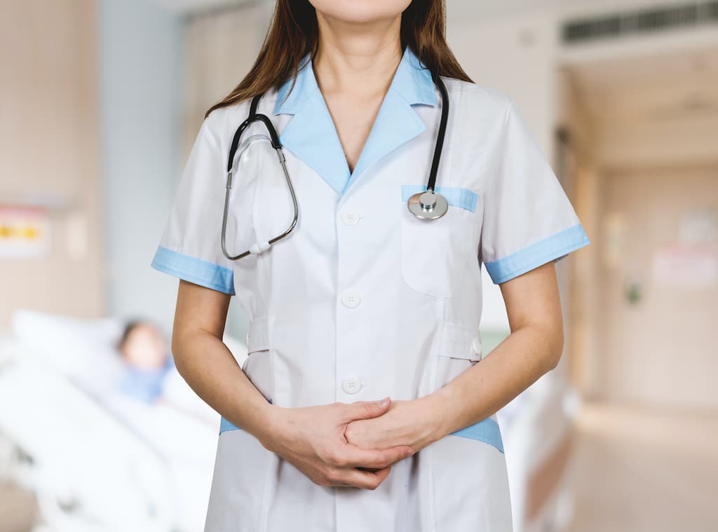 A female doctor with a stetoscope wearing a white uniform