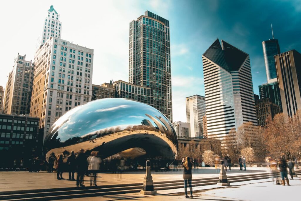 People walking around the "Cloud Gate" sculpture in Chicago in the fall