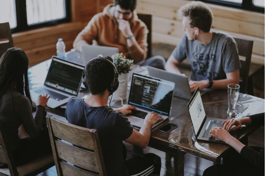 People sitting at their laptops around the table and working