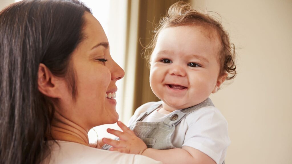 Mom holding a baby and smiling