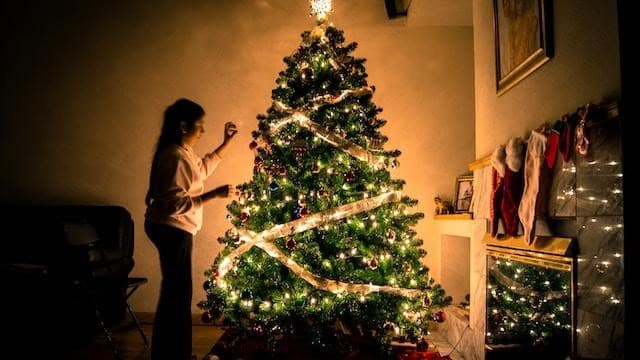 A lady decorating a Christmas tree