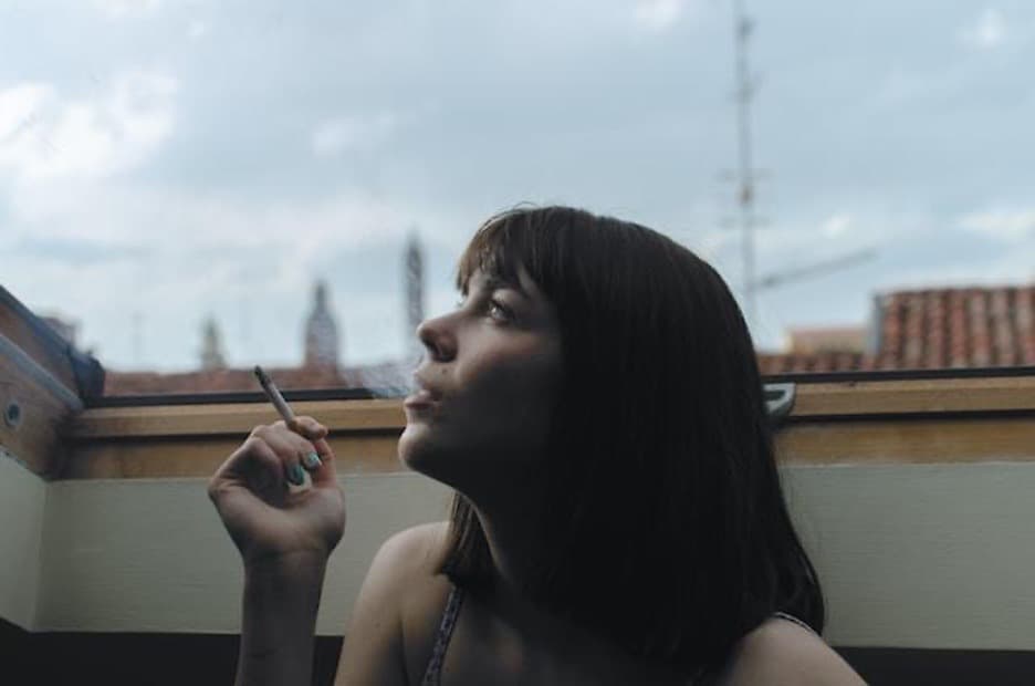 A young woman smoking a cigarette.
