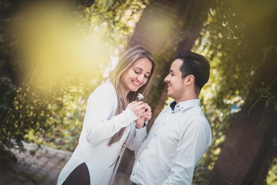 A man giving a white flower to a woman.