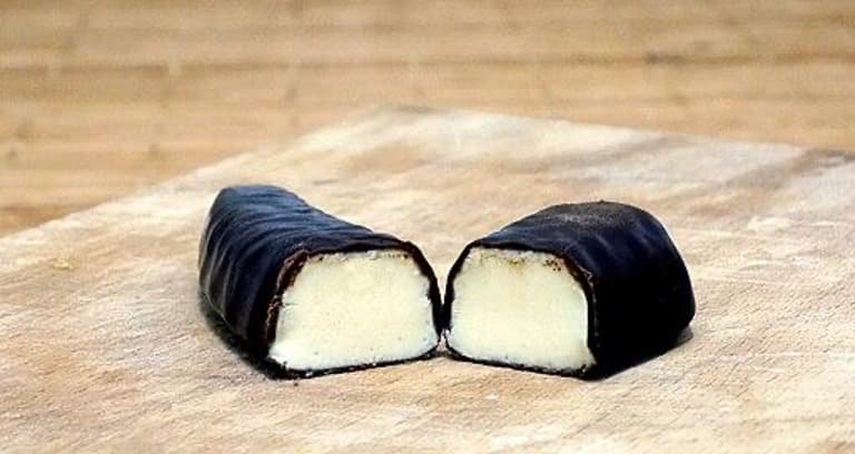 A chocolate snack with white filling split in half.