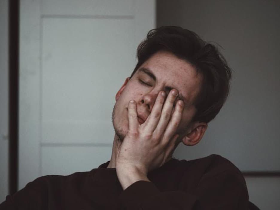 A man with his hand on his face.
