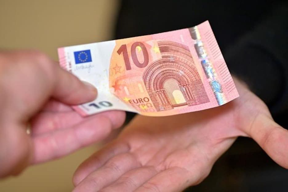A had holding a 10 euros bill.