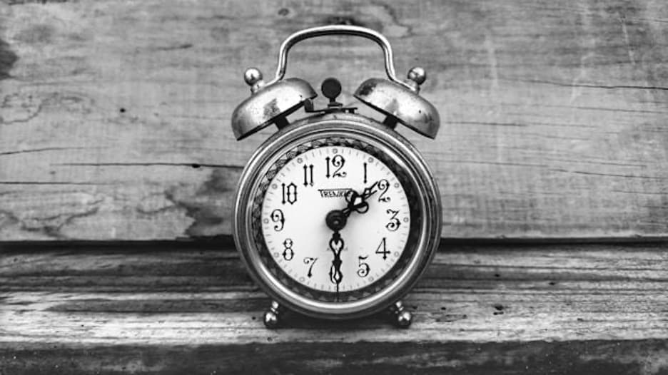 A gray alarm clock showing 1:30