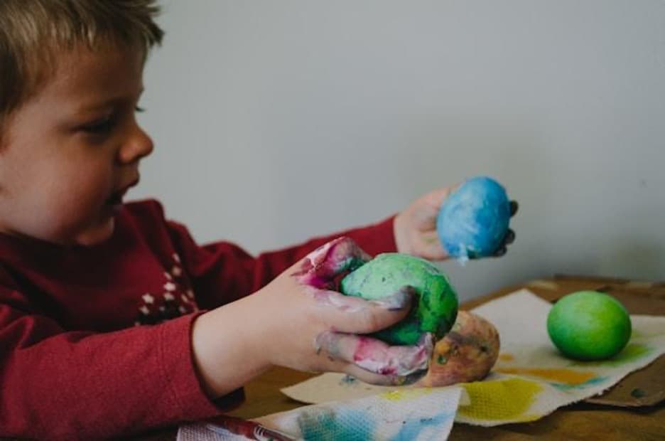 A child coloring eggs, preparing for Easter in Serbia