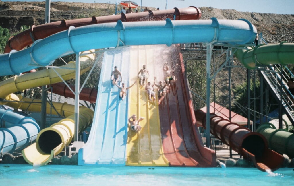 Children on a colorful waterslide at an aquapark.