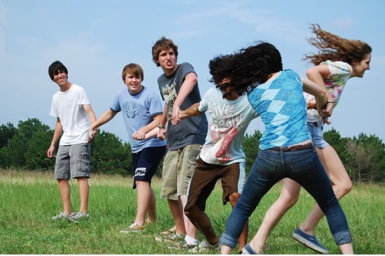 Kids standing in a field, playing a game.