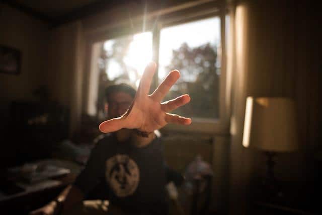 A man reaching forward with an open hand.
