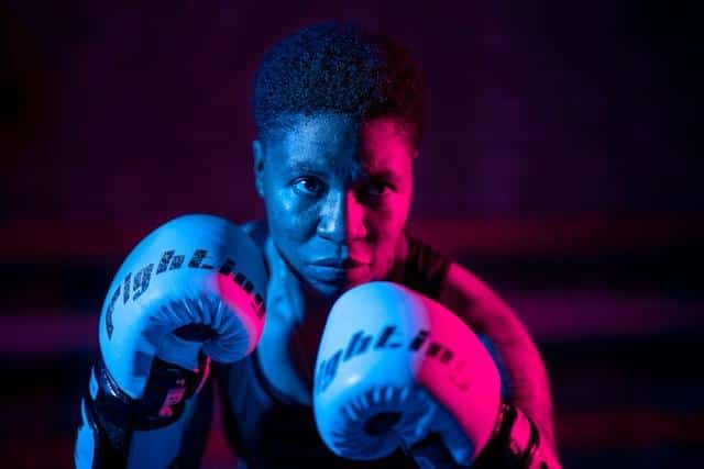 A man with boxing gloves looking at the camera.