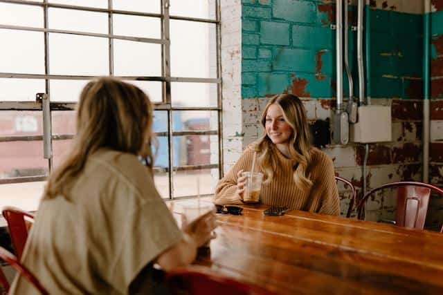 Two women at a cafe drinking coffee.
