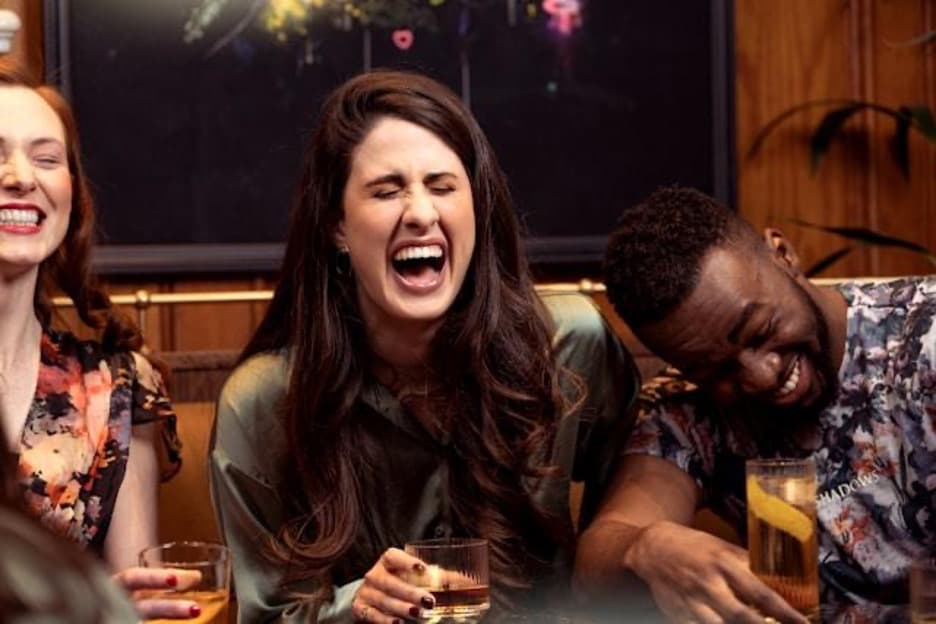 One man and two women laughing out loud.