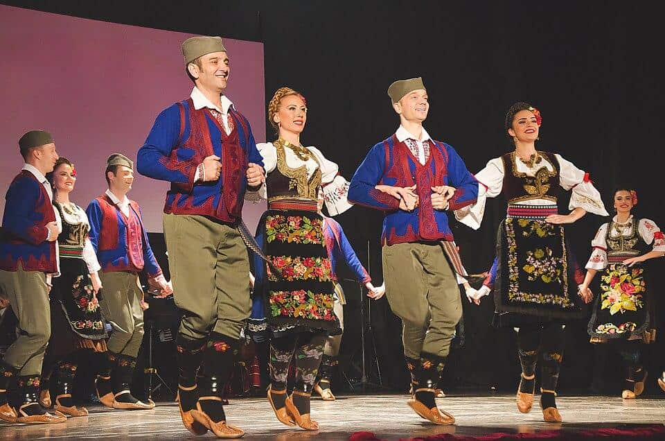 A group of people performing a Serbian traditional dance.