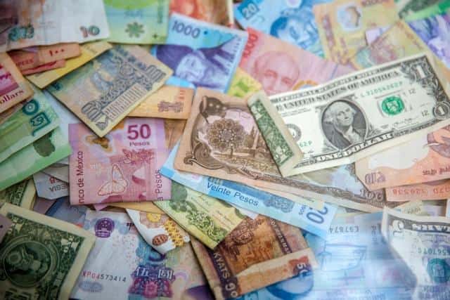 A pile of banknotes in different currencies.