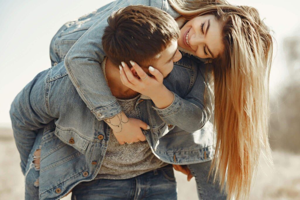 Happy young couple having fun and kissing while walking in the countryside.