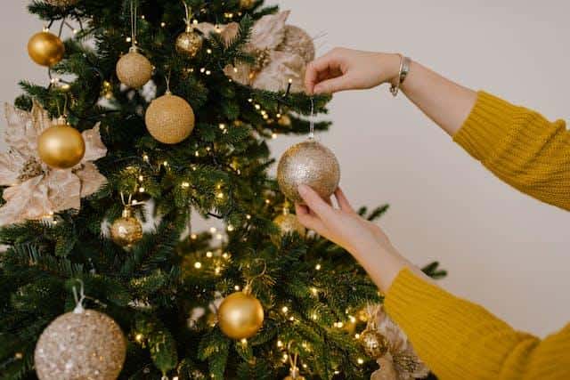 A woman decorating a Christmas tree.