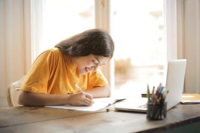 A woman smiling while studying Serbian cases explained in a simple way.